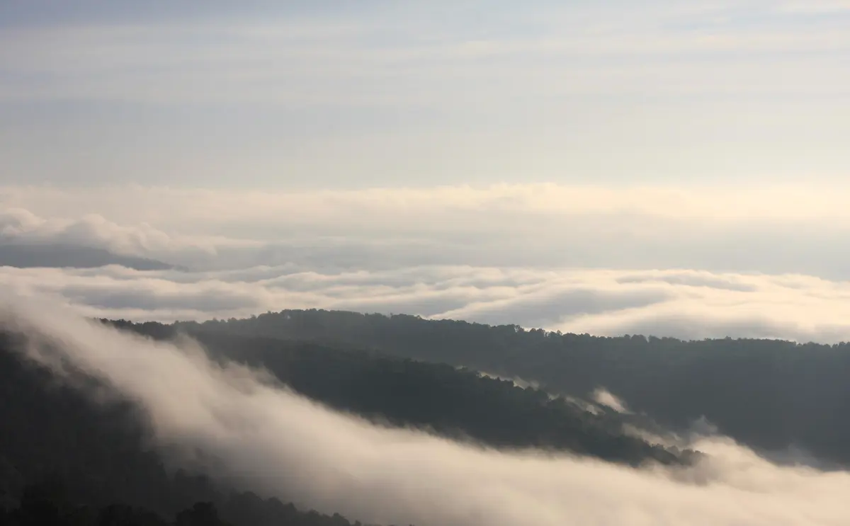 Morning fog pooled below a mountain ridgeline