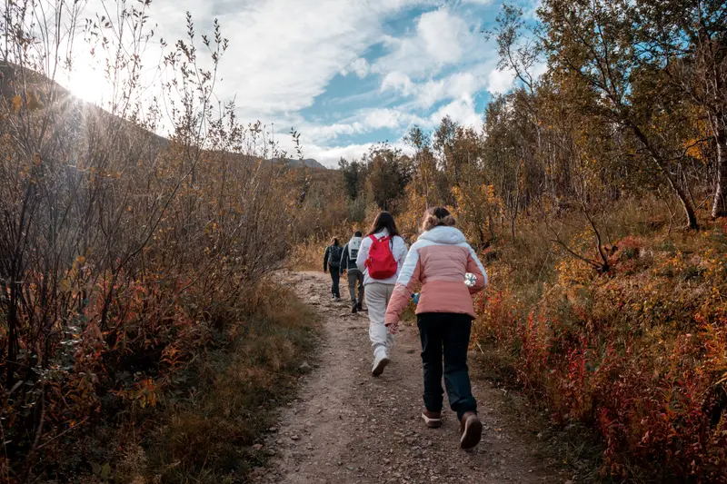 A family hiking a wooded trail in autumn