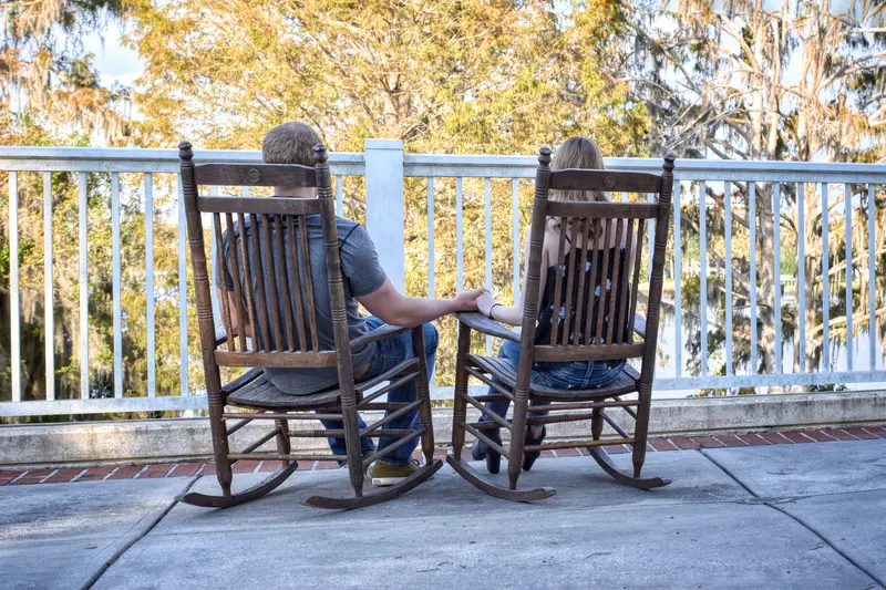 A couple enjoying a peaceful moment on a porch with a scenic nature view.